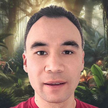 Close-up portrait of a man with a forest background.