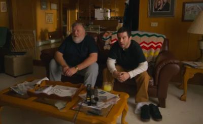 Two men sitting on a couch in a cozy living room.