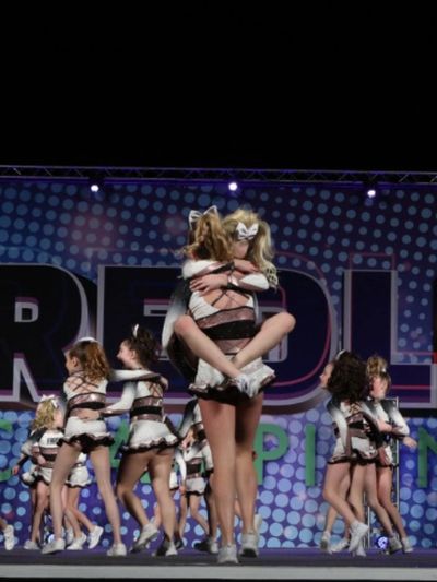 Fargo All Stars cheerleaders hugging after hitting a routine