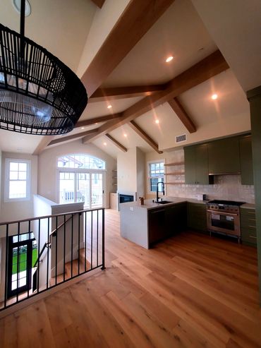 Modern kitchen with wooden beams and large windows.