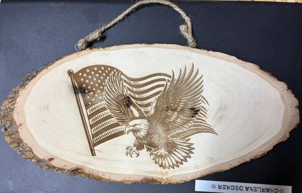 Wooden plaque with a carved American flag and eagle.