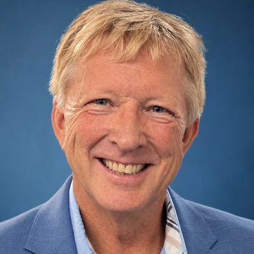 Smiling middle-aged man with blond hair in a blue blazer.