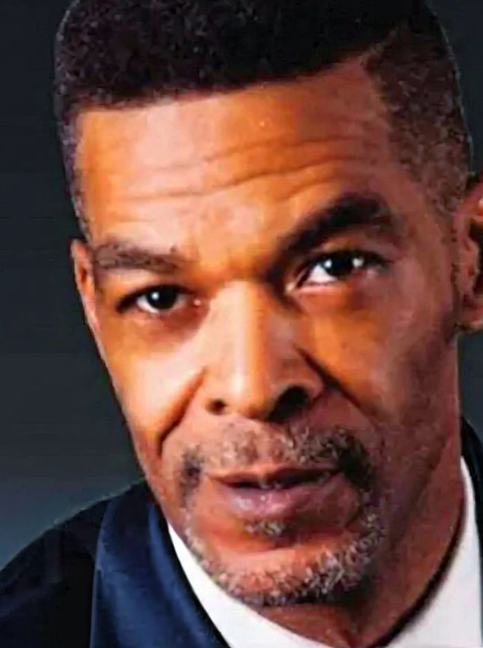 Portrait of a middle-aged man with a serious expression in formal attire.