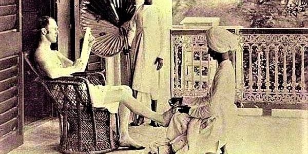 Man reading while servant massages his feet.