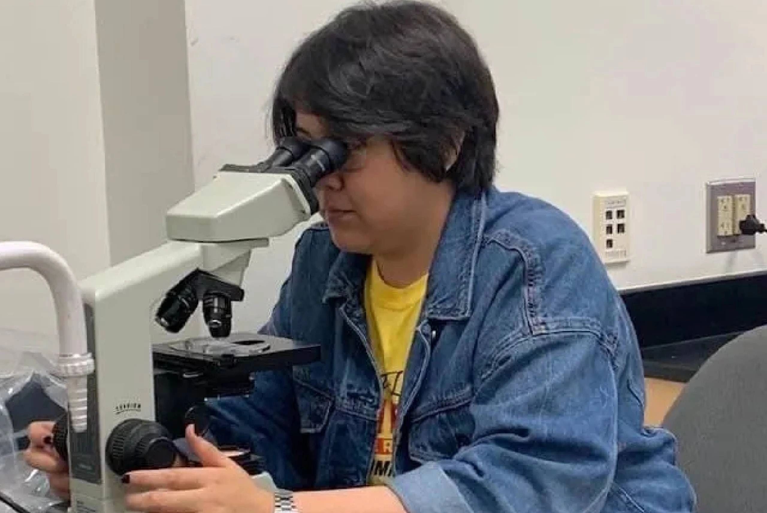 A Woman Looking Through the Microscope