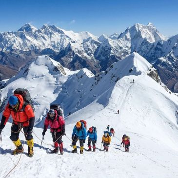 Group of climbers ascending a snowy mountain ridge.