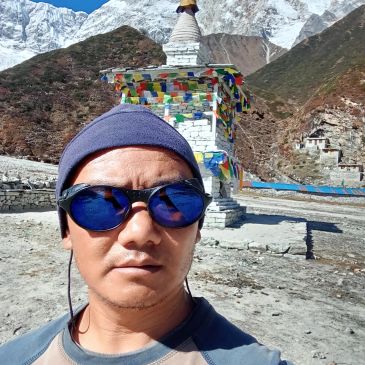 Selfie with prayer flags and snow-capped mountains.