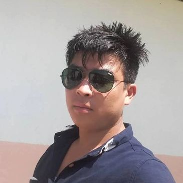 Man wearing sunglasses and navy shirt, taking a selfie.