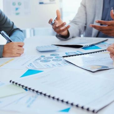 Business meeting with documents and discussions.