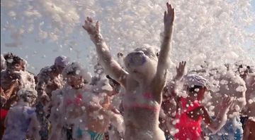 People covered in foam bubbles dancing. Foam party rental. Bounce House Rental add on.