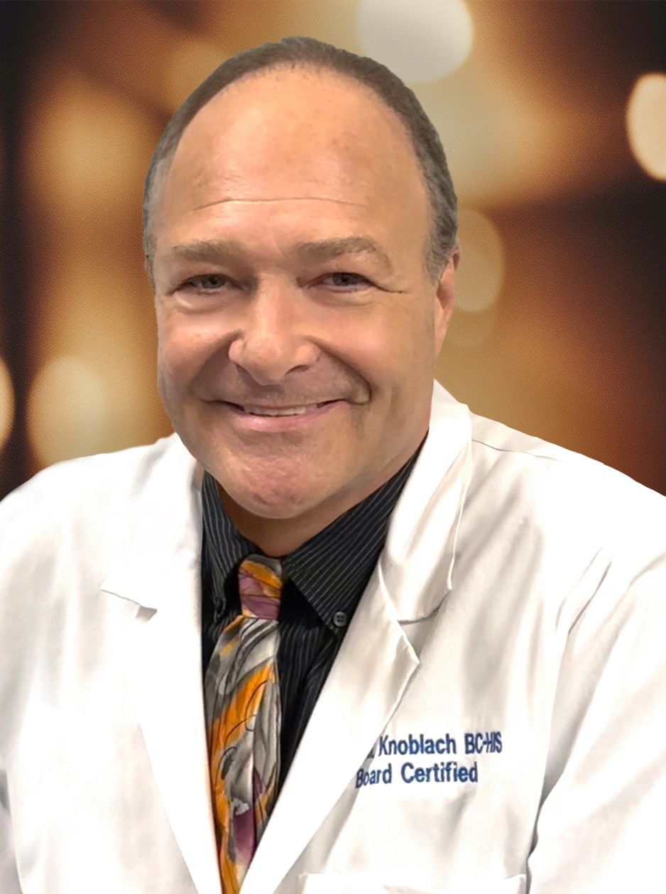 Smiling doctor wearing a white coat and colorful tie.