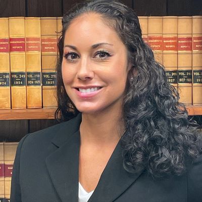 Professional woman smiling in front of bookshelves.