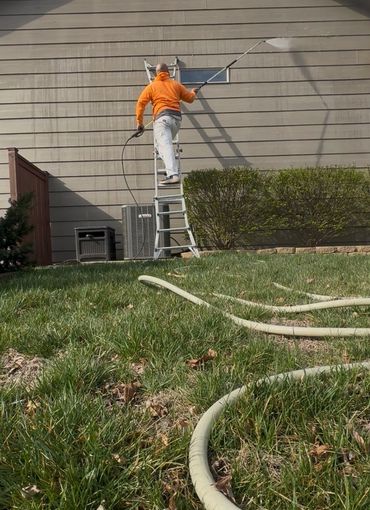 a picture pressure washing the side of a home.