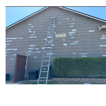 Prepping the side of a house with caulking and primer.