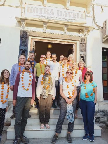 A group of guests at the hotel's main gate with a garland.