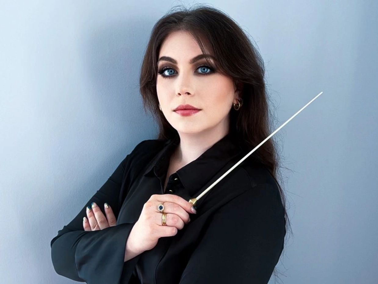 Woman with dark hair holding a wand.