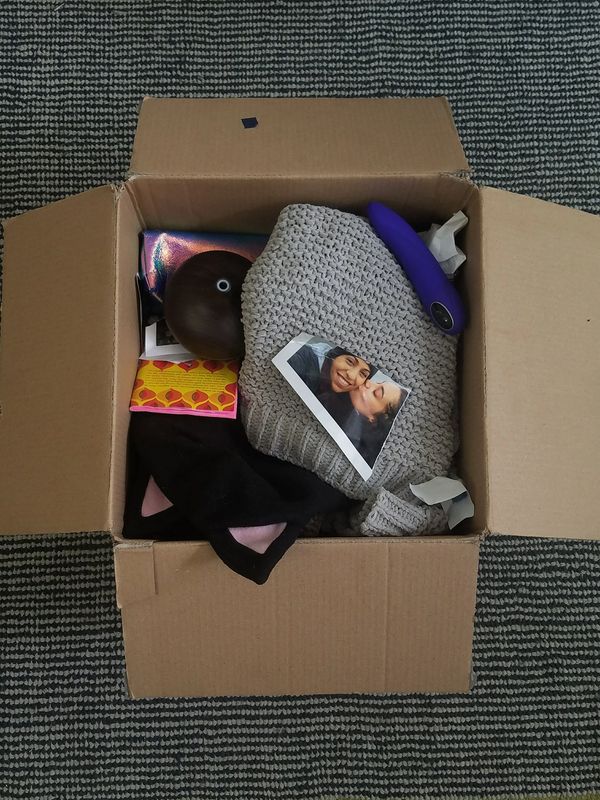 Cardboard box open exposing personal 
"break up" items. Zine, Vibrator, Cat ear hat, makeup bag,etc.