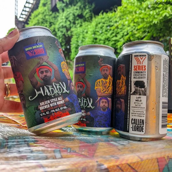 Three cans of Habibx beer are displayed with a Bronx subway train in the background.