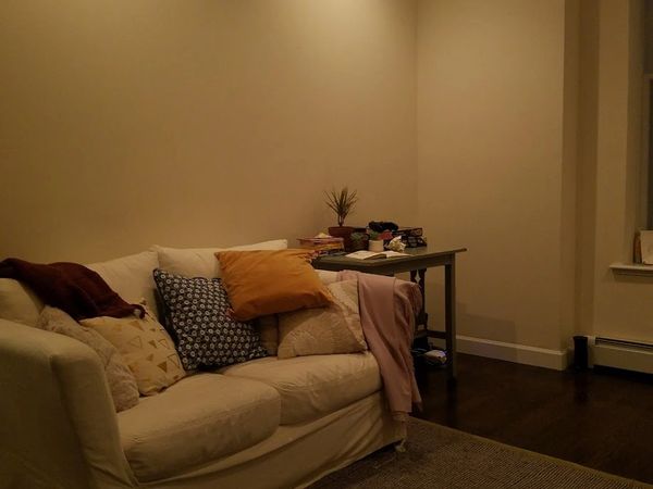 Warmly lit living room is tidy and colorful.