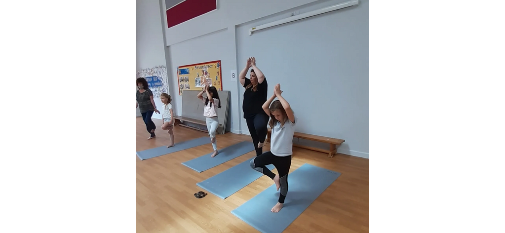 Children practicing tree posture: Vrikasana