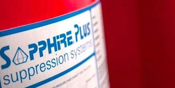 Close-up of a label on a red fire suppression system container.