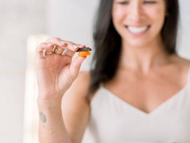 Smiling while holding an apricot and chocolate