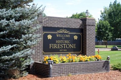 Welcome sign for Historic Firestone surrounded by flowers.
