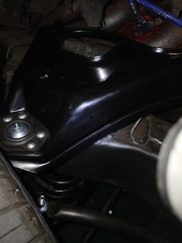 Close-up view of a black vehicle suspension component near the tire.