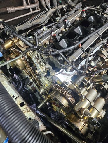 Close-up of a car engine's timing chain and components during repair.