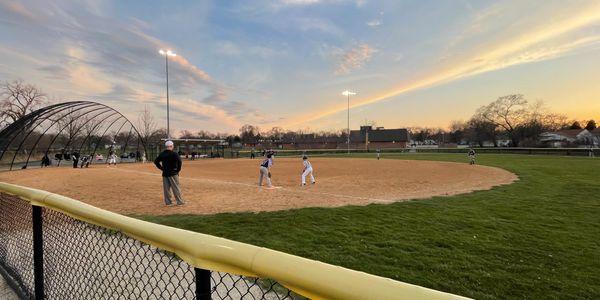 An evening baseball game with some sunset rays