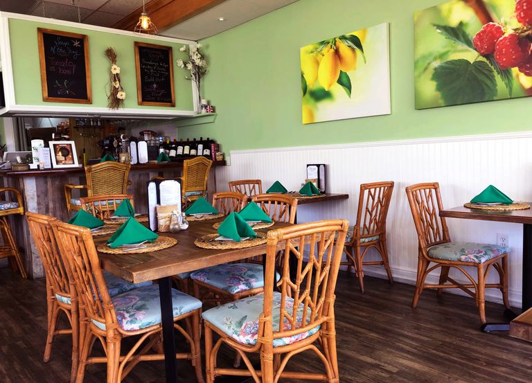 Photo of the Interior of Cremesh Restaurant. Green walls and rattan seating.