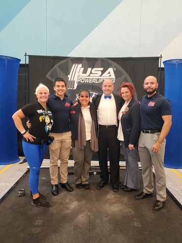 Group photo of six people at a USA Powerlifting event.