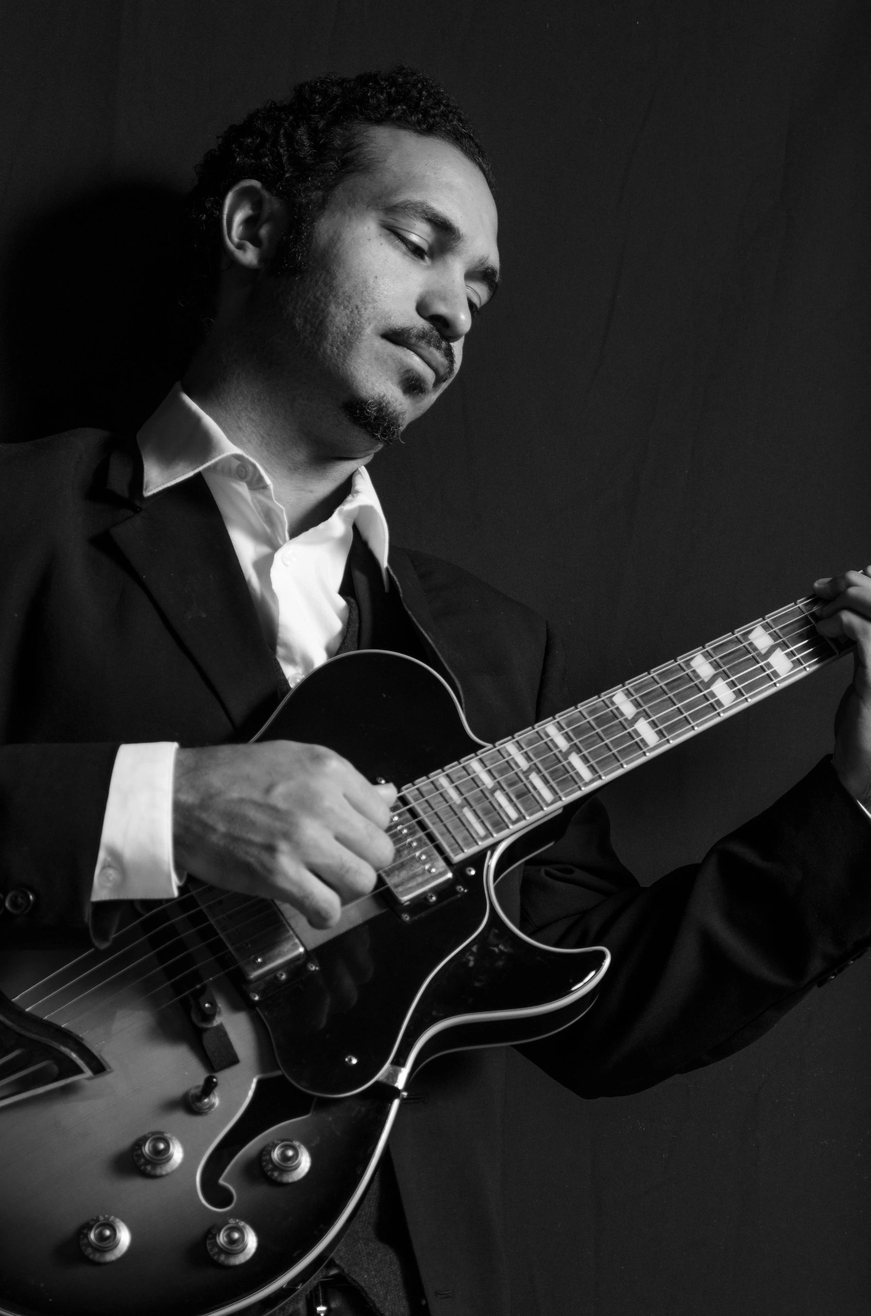 Stack of books next to pencils in a holder and a camera.