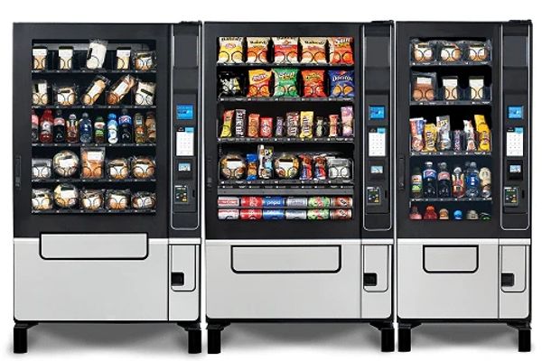 Three vending machines stocked with snacks and drinks.
