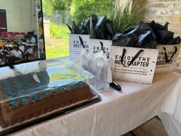 Chocolate cake and gift bags on a decorated table.