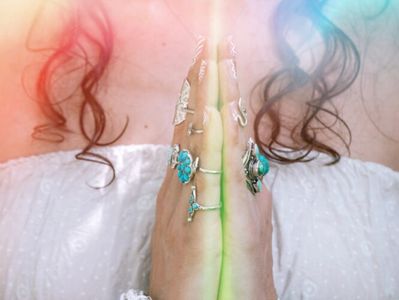 Spiritual light shining from a woman’s hands in prayer position, symbolizing peace and reiki energy