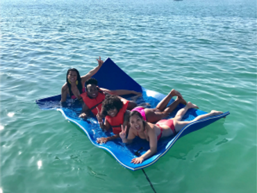 Sandbar Boat tour Girls having fun on Floating Mat at the