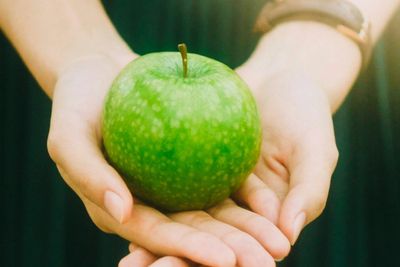 Woman holding green apple