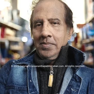 Close-up portrait of a middle-aged man wearing a denim jacket and black sweater.