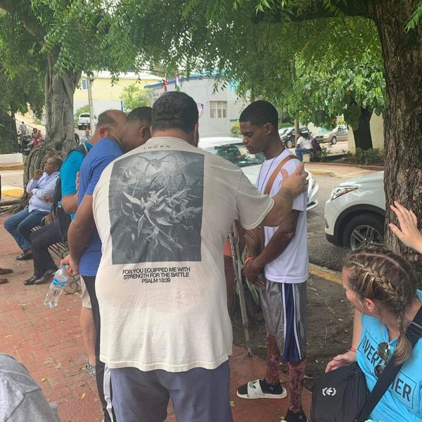 Dewayne praying over kid.