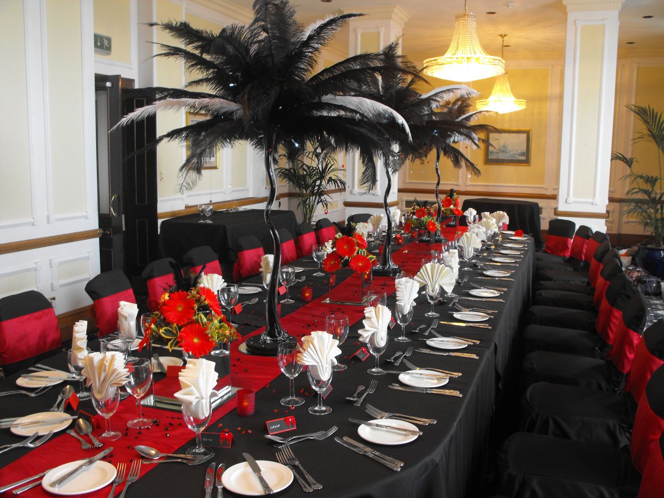 Black and red themed wedding. with tall ostrich plumes, mirrored cube vases with red gerbera's. 