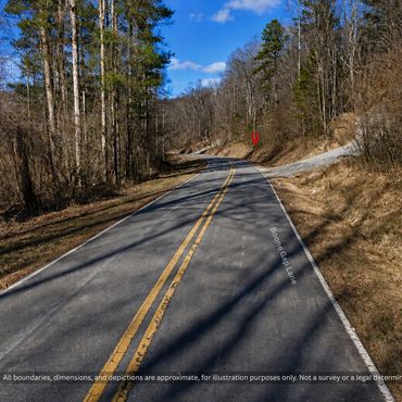 Paved country road through hardwoods near wooded land for sale in Taylorsville NC