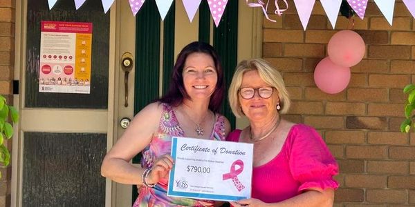 Director of YUSS handing a donation certificate to a lady raiding funds for breast cancer 2023
