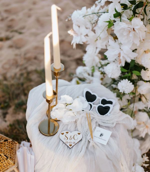 Elegant wedding table setup with candles, flowers, and heart-shaped accessories.