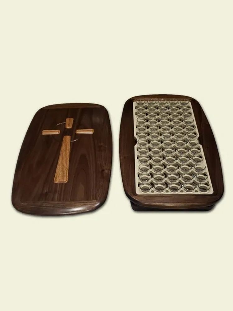 Open wooden tray that holds communion cups made of glass.