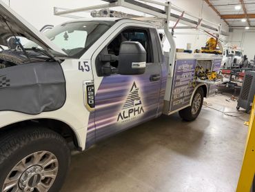 Service truck from Alpha Overhead Doors in a workshop.