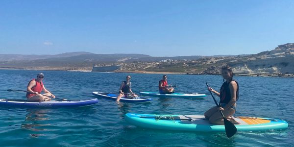 group of friends paddle boarding paphos