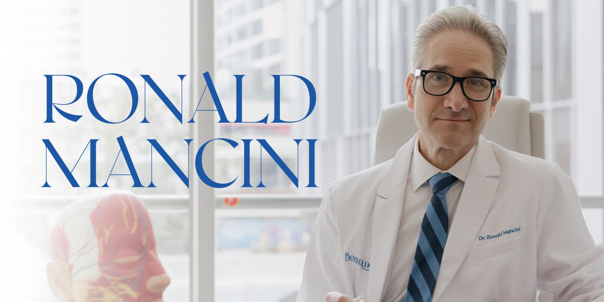 Dr. Ronald Mancini in a white coat, smiling in a bright office.