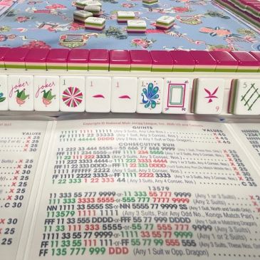 Mahjong game setup with tiles and scoring chart.
