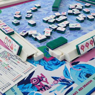 Mahjong game in progress with tiles on a colorful table.